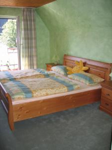 a bedroom with a wooden bed with a teddy bear on it at Pension & Ferienhaus Latröpchen in Schmallenberg