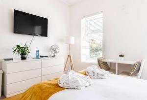 a white bedroom with a bed with towels on it at Liberties Pre63 Studios in Dublin