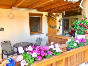 een veranda met bloemen en een tafel en stoelen bij Rennerhof-Siebeneichen Fewo Waschbär in Sulzbach-Rosenberg
