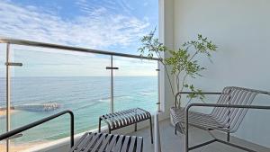 twee banken op een balkon met uitzicht op de oceaan bij 윤슬 스테이-슬 in Sajin