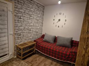 a living room with a couch and a brick wall at Haus an der Dorfteichstraße in Alt Krenzlin