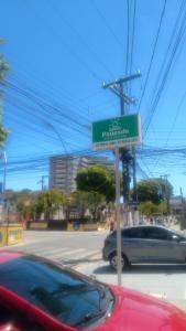 a sign for a car dealership on a street at Pousada praia avenida in Maceió