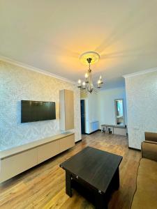 een woonkamer met een bank en een tv aan de muur bij Nice Stay Near Center in Jerevan