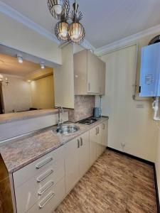 een keuken met witte kasten en een spoelbak bij Nice Stay Near Center in Jerevan