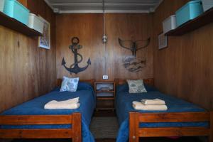 ein Zimmer mit zwei Betten und einem Anker an der Wand in der Unterkunft Chacra La Elena - Casa container a 15km de Madryn in Puerto Madryn