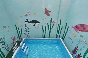 una stanza per bambini con un murale di pesci e una piscina di Villa Erontas -mini pool and heated jacuzzi a Makhairoí