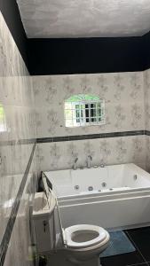 un bagno con una vasca bianca e un water di Doreen's Ranch Master Suite a Four Paths