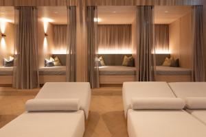 2 witte bedden in een kamer met spiegels bij Aktivhotel Pehab - Dachstein Rooftop-Spa in Ramsau am Dachstein