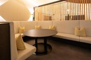 een salontafel en een bank met een tafeltje en kussens bij Aktivhotel Pehab - Dachstein Rooftop-Spa in Ramsau am Dachstein