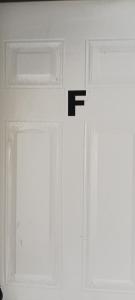 twee ramen in een kamer met de letter f op de muur bij Hospedaje Valdes in Puerto Montt