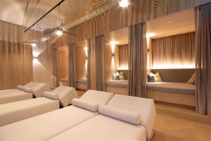 een woonkamer met witte meubels en 2 bedden bij Aktivhotel Pehab - Dachstein Rooftop-Spa in Ramsau am Dachstein