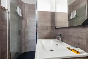a bathroom with a white sink and a shower at Blue Bay rooms in Cala Gonone