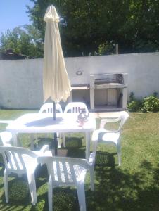 a white table with two chairs and an umbrella at Los Abuelos in Dolores