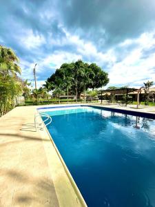 a large blue swimming pool with trees in the background at Finca Hotel Buenos Aires in Guamal