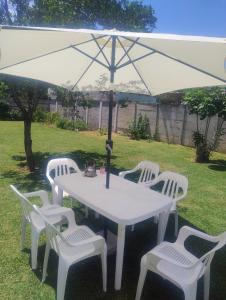 een witte tafel en stoelen onder een parasol bij Los Abuelos in Dolores