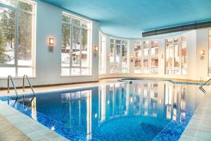een zwembad in een huis met ramen bij STRIM Apartment 406 Stream Resort, Pamporovo in Pamporovo