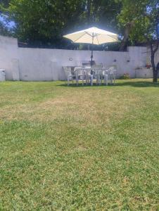 een tafel en stoelen onder een paraplu in een tuin bij Los Abuelos in Dolores