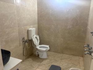 a bathroom with a toilet with the lid up at Rainbow721 Earth in Pondicherry