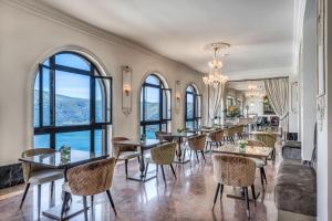 a dining room with tables and chairs and large windows at Hotel Castel Vecchio in Castel Gandolfo