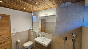 a bathroom with a sink and a toilet and a mirror at Mountain Suite Brixen in Brixen im Thale +16 photos