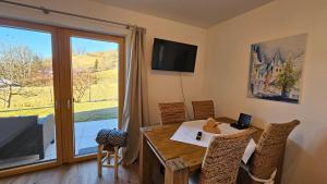 a dining room with a table and a large window at Mountain Suite Brixen in Brixen im Thale