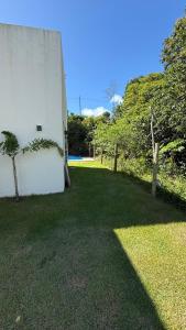 un edificio bianco con una palma accanto a un cortile di Casa aconchego a Santa Cruz Cabrália