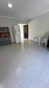 una stanza vuota con un frigorifero, un tavolo e delle sedie di Casa aconchego a Santa Cruz Cabrália