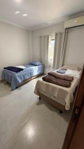 una camera da letto con due letti e una finestra di Casa aconchego a Santa Cruz Cabrália Altre 13 foto