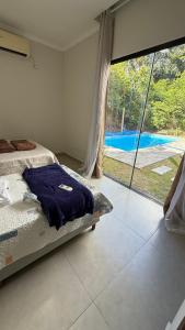 una camera con letto e vista sulla piscina di Casa aconchego a Santa Cruz Cabrália