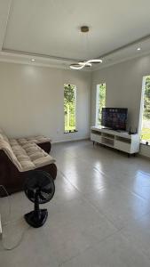 un soggiorno con divano e TV a schermo piatto di Casa aconchego a Santa Cruz Cabrália