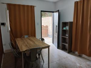 una sala da pranzo con tavolo, sedie e una porta di Departamentos de Campo Solar de las Chacras a Juana Koslay 
