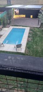 una vista dall'alto di una piscina con una sedia accanto di Departamentos de Campo Solar de las Chacras a Juana Koslay  Altre 4 foto