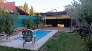 una sedia seduta accanto a una piscina in un cortile di Departamentos de Campo Solar de las Chacras a Juana Koslay 