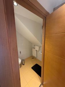 een zolderbadkamer met toilet en deur bij Apartament H&C in Madrid