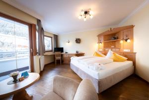 a hotel room with two beds and a desk at Hotel Trisanna in Ischgl