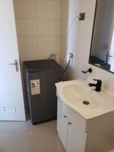 a bathroom with a sink and a washing machine at Zapahuira in Arica +1 photo