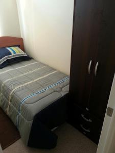 a small bedroom with a bed and a cabinet at Zapahuira in Arica