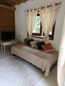 En eller flere senge i et værelse på Casinha Verde- Hospedagem Itaobi - Arraial d Ajuda - Pedra Azul-Estrada da Pitinga + 11 billeder