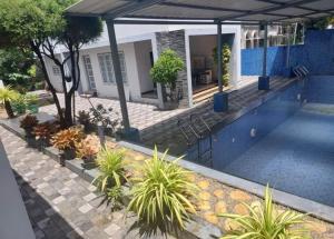 a view of a house with a pool and plants at Krishnamadom in Kollam