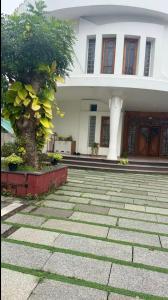 a house with a tree in front of it at Krishnamadom in Kollam
