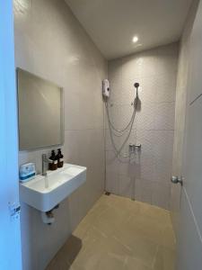 een badkamer met wastafel en douche met spiegel bij Acacia Phuket in Nai Harn Beach
