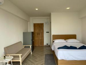 een slaapkamer met een bed, een stoel en een deur bij Acacia Phuket in Nai Harn Beach