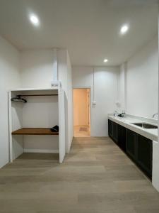 een witte keuken met een wastafel en een aanrecht bij Acacia Phuket in Nai Harn Beach