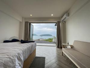 een slaapkamer met een bed en uitzicht op de oceaan bij Acacia Phuket in Nai Harn Beach