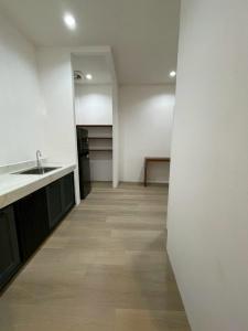 een lege kamer met een wastafel en een keuken bij Acacia Phuket in Nai Harn Beach +12 foto's