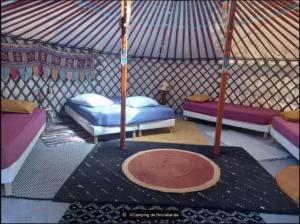 a room with three beds in a yurt at camping de brocéliande in Néant-sur-Yvel