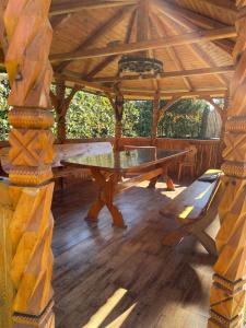 eine Tischtennisplatte in einem Pavillon mit einer Bank in der Unterkunft Cabana Lac in Sadu