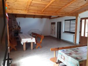 a living room with a wooden ceiling and a table at Cabana Lac in Sadu