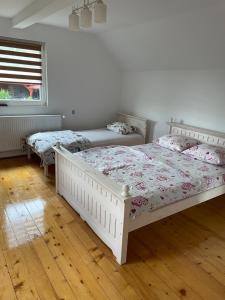 ein Schlafzimmer mit zwei Betten und einem Fenster in der Unterkunft Cabana Lac in Sadu