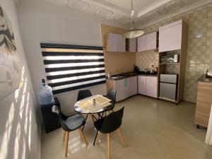 a small kitchen with a table and chairs at Flamingo 1 spacious solar powered 2 bedroom home with a stocked ready kitchen in Jos